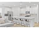 Modern kitchen boasts stainless appliances, white cabinets and a large island with bar stool seating at 10165 Canyon Mantle St, Las Vegas, NV 89166