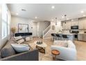 Open-concept living room with modern decor, flowing into a kitchen with counter seating, ideal for entertaining at 11561 Cedar Shore Ave, Las Vegas, NV 89138