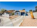 Inviting single-story home with a blue exterior, desert landscaping, and a concrete driveway at 1315 Chatsworth Ct, Las Vegas, NV 89142