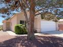 Charming home with well-maintained landscaping, a large shade tree, and a two-car garage at 1907 Thunder Storm Ave, North Las Vegas, NV 89032