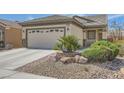 Well-maintained house showcasing desert landscaping and a two-car garage at 2409 Garganey Ave, North Las Vegas, NV 89084