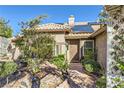 Inviting front entrance featuring a decorative door and lush, mature landscaping at 263 Baring Cross St, Henderson, NV 89074
