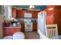 Functional kitchen with wood cabinets, white appliances, and tiled floors at 4432 Faberge Ave, Las Vegas, NV 89115