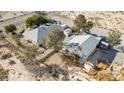Aerial perspective showcases the property's layout with two houses, sheds, landscaping, and large outdoor space at 4838 N Tioga Way, Las Vegas, NV 89149