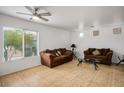 Bright living room featuring tile floors, comfortable seating, and a ceiling fan, perfect for relaxation and entertaining at 6234 Pangea Ave, Las Vegas, NV 89139