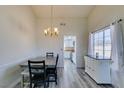 Inviting dining room with gray wood floors, modern chandelier, and a view into the updated kitchen at 6357 Vicuna Dr, Las Vegas, NV 89146
