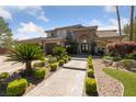 Beautiful two-story home with stone accents, lush landscaping, and inviting walkway at 637 Edgebrook Dr, Las Vegas, NV 89145