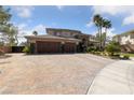 Elegant two-story home with a three-car garage, stamped concrete driveway, and manicured landscaping at 637 Edgebrook Dr, Las Vegas, NV 89145