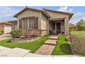 Inviting single-story home with a stone accent wall, desert landscaping, and brick walkway at 660 Otter Brook St, Henderson, NV 89011