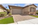 The front exterior has a two-car garage and a beautiful brick driveway at 660 Otter Brook St, Henderson, NV 89011