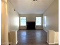 Inviting living room featuring wood-look tile floors, a fireplace, and plenty of natural light at 6632 Coastal Breeze Ct, Las Vegas, NV 89108