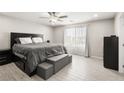 Comfortable main bedroom with a large bed, storage ottoman, neutral walls, and bright window with natural light at 70 Pikiariki Ct, Las Vegas, NV 89183