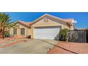 Charming home featuring a well-maintained yard, tile roof, solar panels and an attached two-car garage at 702 Carlitos Ave, North Las Vegas, NV 89031
