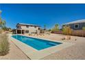 Large backyard showcasing a long, narrow swimming pool, desert landscaping, and the rear facade of the home at 7736 Tioga Ridge Ct, Las Vegas, NV 89117