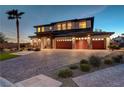 Stunning exterior view of the two-story home with a brick driveway and three-car garage at 7736 Tioga Ridge Ct, Las Vegas, NV 89117