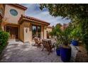 A covered outdoor patio and sitting area with stone flooring and manicured landscaping at 7988 Pinnacle Peak Ave, Las Vegas, NV 89113