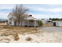 Two story white home with a covered carport and additional out building at 861 Mcmurray Dr, Pahrump, NV 89060