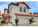 Beautiful two-story home showcasing a white exterior, red tile roof, and well-maintained front yard at 8789 Villa Alex Ave, Las Vegas, NV 89147