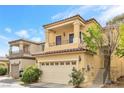 Inviting tan home featuring a small balcony, two-car garage, and well-kept front yard landscaping at 9617 Sharp Horn Ct, Las Vegas, NV 89149