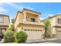 Attractive two-story tan house with a balcony, attached two-car garage, and tidy landscaping at 9617 Sharp Horn Ct, Las Vegas, NV 89149