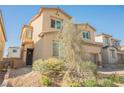 Two-story home with neutral color, desert landscaping and a two-car garage at 10415 Andele Ave, Las Vegas, NV 89166