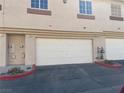 Attached two-car garage, offering convenient parking and storage, with a red painted curb at 1308 Dusty Creek St, Las Vegas, NV 89128