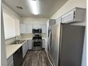 Modern kitchen featuring stainless steel appliances and light gray cabinets with wood-look flooring at 1308 Dusty Creek St, Las Vegas, NV 89128