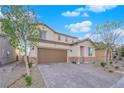 Charming two-story home with stone accents, a well-maintained yard, and a paved driveway at 1909 Pinsky Ln, North Las Vegas, NV 89032