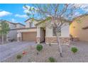 Charming two-story home with stone accents, a well-maintained yard, and a paved driveway at 1909 Pinsky Ln, North Las Vegas, NV 89032
