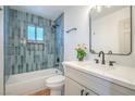 Stylish bathroom showcasing blue tiled walls, tub, and modern vanity with quartz countertop at 1945 Margarita Ave, Henderson, NV 89011