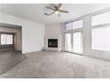 An open living room featuring a fireplace, plush carpeting, and double doors with an abundance of natural light at 2124 Brighton Shore St, Las Vegas, NV 89128