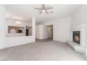 An open living room featuring a fireplace, plush carpeting, and views of the kitchen at 2124 Brighton Shore St, Las Vegas, NV 89128