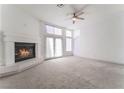 An open living room featuring a fireplace, plush carpeting, and double doors with an abundance of natural light at 2124 Brighton Shore St, Las Vegas, NV 89128