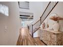 Bright foyer with wood floors, open staircase and charming, antique chest at 2132 Ponticino St, Henderson, NV 89044