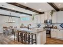 Eat-in kitchen features bright white cabinets, a large island and rustic wood beam details at 2132 Ponticino St, Henderson, NV 89044