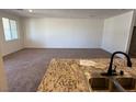 Spacious living room adjacent to kitchen area with granite counters and modern sink at 3667 Inspirato Ave, Henderson, NV 89044