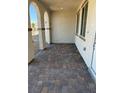 Inviting covered porch area with brick flooring and arched doorway at 3667 Inspirato Ave, Henderson, NV 89044