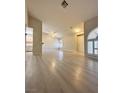 Spacious living room featuring light wood floors, neutral paint, arched windows, and plenty of natural light at 3672 Angela Robin St # 202, Las Vegas, NV 89129