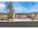 Modern home featuring a three-car garage and desert landscaping at 440 Point Sur Ave, Las Vegas, NV 89138