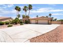 Charming single-story home with a spacious driveway and desert landscaping, complemented by tall palm trees at 5217 Cold River Ave, Las Vegas, NV 89130