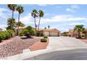 Charming single-story home with a spacious driveway and desert landscaping featuring palm trees at 5217 Cold River Ave, Las Vegas, NV 89130