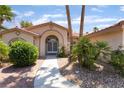 Inviting front entrance with an arched doorway, decorative plants, and a well-maintained walkway at 5217 Cold River Ave, Las Vegas, NV 89130