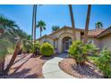 Inviting front entrance with lush landscaping and a decorative arched doorway and walkway at 5217 Cold River Ave, Las Vegas, NV 89130