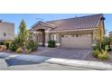 Inviting single-story home boasts stone detailing, a tiled roof, a two-car garage, and mature landscaping at 5977 Ancient Peaks Ave, Las Vegas, NV 89141