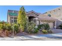 Beautiful single-story home featuring a tile roof, stone accents, mature landscaping, and an attached two-car garage at 5977 Ancient Peaks Ave, Las Vegas, NV 89141