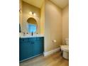 Stylish half bath with modern fixtures, vanity with blue cabinets and updated features perfect for guests at 6495 Little Harbor Ct, Las Vegas, NV 89141