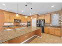 Spacious kitchen featuring wooden cabinetry, granite counters, and a large central island at 8216 Swallow Falls St, North Las Vegas, NV 89085