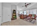 Inviting living room featuring neutral tile floors, a ceiling fan, and comfortable leather furniture at 9037 Grayling Dr, Las Vegas, NV 89134