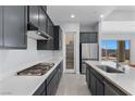 Spacious kitchen featuring gray cabinets, quartz countertops, and stainless steel appliances at 10158 Super Jovian St, Las Vegas, NV 89143