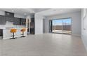 Open-concept living space with tile flooring, modern kitchen, and sliding glass doors to the backyard at 10158 Super Jovian St, Las Vegas, NV 89143